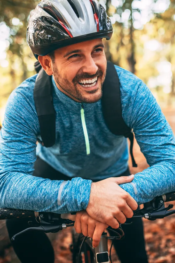 A smiling man getting ready for a cycling trip. Get treatment for adrenal hormone disorder from Tanya Zboril, NP of TBT Medical in Ottawa–Gatineau.