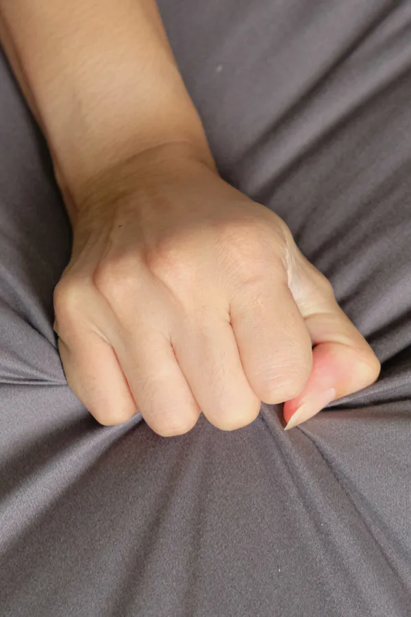Close-up of a woman's hand grabbing a sheet, indicating sexual pleasure. Get female sexual dysfunction treatment from Tanya Zboril, NP of TBT Medical in Ottawa–Gatineau.