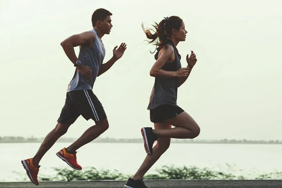 A couple in profile running along the water. Schedule GLP-1 Weight Loss Injections from Tanya Zboril, NP of TBT Medical in Ottawa–Gatineau.