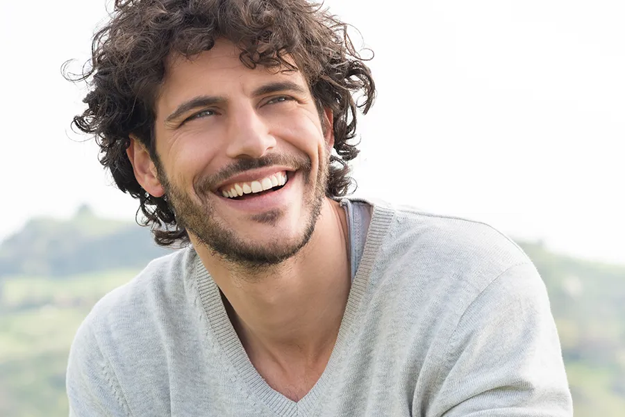Hair-Loss-Clinic A man with radiant curly hair and a confident smile looks to the horizon. Tanya Zboril, NP of TBT Medical in Ottawa–Gatineau offers effective therapies to support hair regrowth and scalp health to treat hair loss.