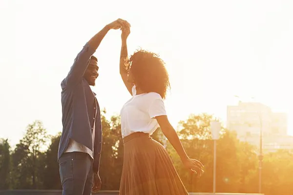 A black couple dances outside lit by the sunset. Get immunotherapy for autoimmune diseases from Tanya Zboril, NP of TBT Medical in Ottawa–Gatineau.