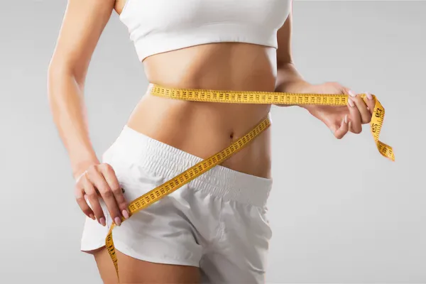 Low-Dose-Naltrexone-for-Weight-Loss-Doctor A woman wraps a measuring tape around her waist to show the success of her Low Dose Naltrexone for Weight Loss treatments from Tanya Zboril, NP of TBT Medical in Ottawa–Gatineau.