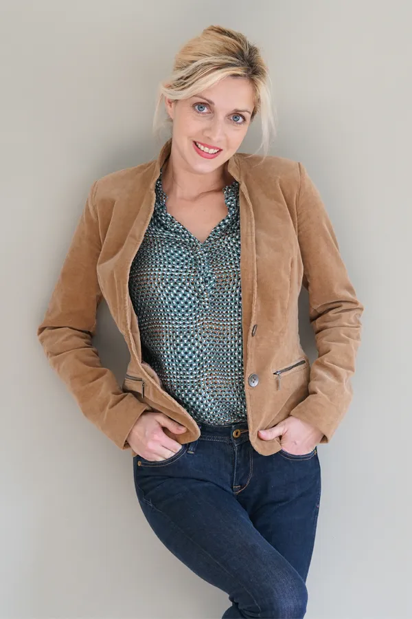A smiling blonde woman in a tan leather jacket leans against a gray wall. Schedule metabolic syndrome from Tanya Zboril, NP of TBT Medical in Ottawa–Gatineau.