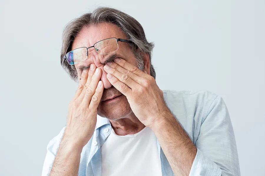 Get migraine relief with Tanya Zboril, NP of TBT Medical's functional medicine for migraines treatment in Ottawa–Gatineau, represented by an older man rubbing his eyes due to head pain.