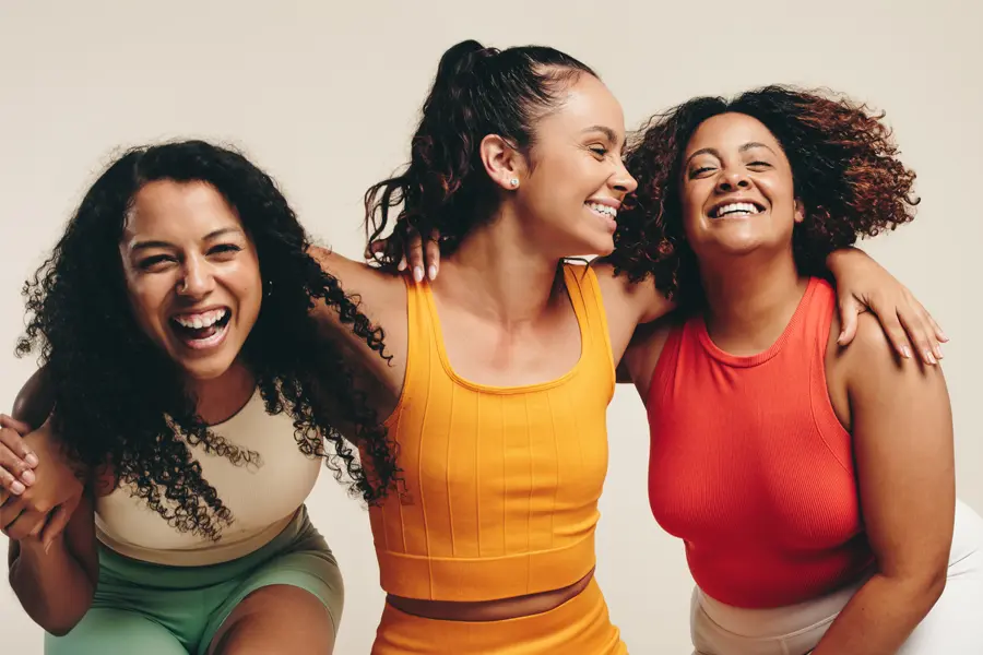 Three healthy women in colorful clothes laugh arm in arm. Schedule Mounjaro for weight loss from Tanya Zboril, NP of TBT Medical in Ottawa–Gatineau.