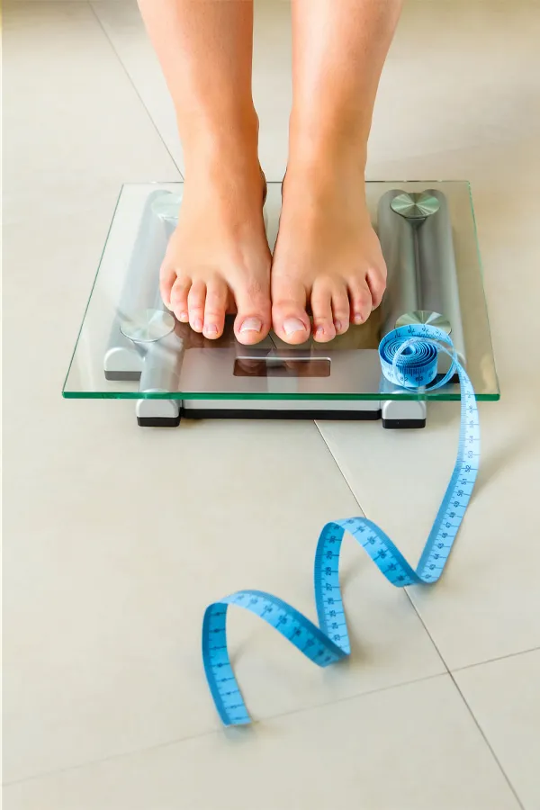 Ozempic-Treatment Feet on a scale with a measuring tape for weight loss. Get Ozempic for weight loss from Tanya Zboril, NP of TBT Medical in Ottawa–Gatineau.