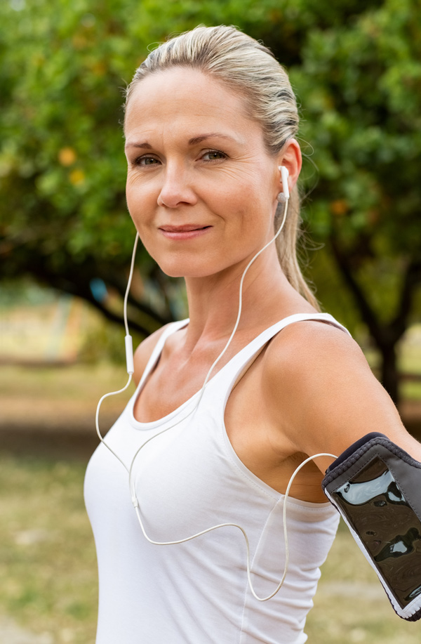 Middle-aged, active woman taking a break to smile at the camera during a run, representing successful Bioidentical Hormones for Fibromyalgia Relief offered by Tanya Zboril, NP of TBT Medical in Ottawa–Gatineau.